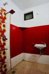 a bathroom with a sink and a red wall at BLISS STAYS in Rishīkesh