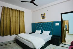 a bedroom with a bed with a blue headboard at BLISS STAYS in Rishīkesh