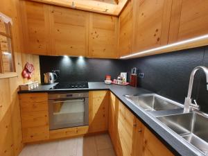 a kitchen with wooden cabinets and a sink at Daniela Apartment in Cortina dʼAmpezzo