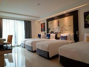 een hotelkamer met drie bedden in een kamer bij Hotel Clover Asoke - SHA Extra Plus in Bangkok