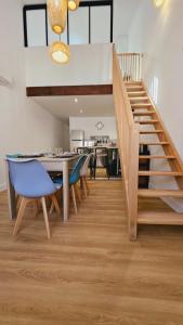 a dining room with a staircase and a table and chairs at Maison rénovée, Agen centre in Agen +8 photos