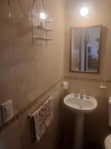 y baño con lavabo y espejo. en cabaña La Retama en Villa Yacanto
