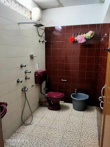 a bathroom with a red toilet and a tub at Imperial Heritage Home in Port Blair