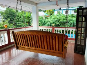 eine Holzschaukel in einem Zimmer mit Balkon in der Unterkunft Imperial Heritage Home in Port Blair