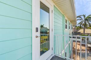una puerta a una casa con balcón en Amber Jack - 210 Ostego Dr home, en Fort Myers Beach