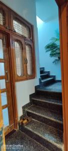 Indipendent Home Stay at Jankupuram Lucknow في لاكناو: وجود حذاء على الدرج بجانب باب
