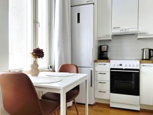 a kitchen with a table and two chairs and a stove at Huoneisto Puusatama, Joensuu in Joensuu