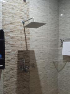 eine Dusche mit Duschkopf im Bad in der Unterkunft Goroomgo Tapovan Residency Haridwar - Excellent Service Recommended in Haridwar
