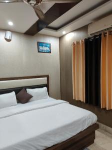 een slaapkamer met 2 bedden en een plafond bij Goroomgo Tapovan Residency Haridwar - Excellent Service Recommended in Haridwār