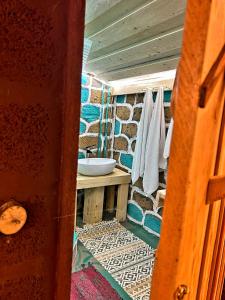 a bathroom with a sink and a stone wall at GreenField Luxe in Yeghegnadzor