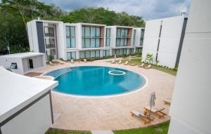 an external view of a hotel with a swimming pool at Brand New 2024 Two Bedroom Jungle View Condo with Pool in Nosara