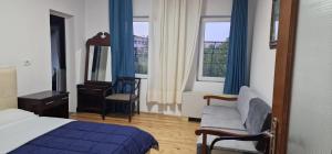 una camera d'albergo con letto, sedia e finestra di Sunrise Lindita a Pukë