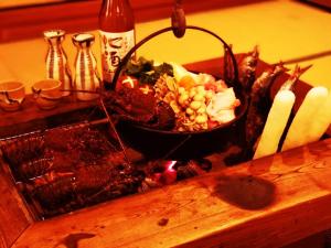 uma mesa com uma tigela de comida e algumas velas em いろり庵 em Tateyama