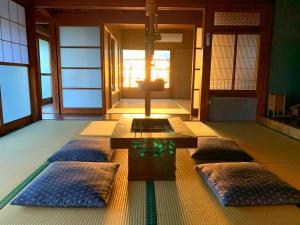 um quarto com quatro almofadas no chão com uma mesa em いろり庵 em Tateyama