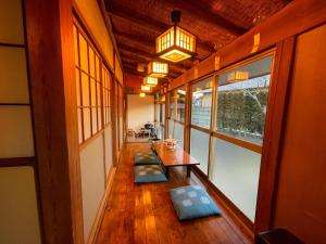 a hallway of a house with benches and windows at いろり庵 in Tateyama