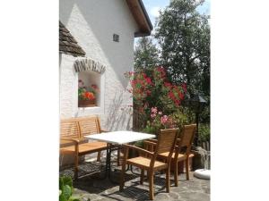Holiday home Goldegg في Artstetten: طاولة وكراسي على فناء به زهور