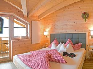 a bedroom with a bed with red and white pillows at Romantic Chalet Waldschlössl in Hippach