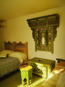 a bedroom with two beds and a table and a mirror at Maison Albatros in Mahdia