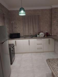 a kitchen with white cabinets and a sink and a refrigerator at luxury 3BD villa in Stella Heights - North Coast فيلا فاخره ستيلا هايتس الساحل الشمالي in El Alamein