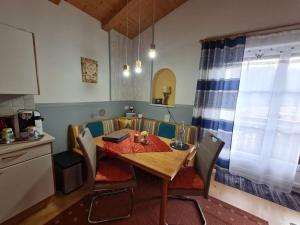 a kitchen with a wooden table and chairs in a room at Comfortabel vakantieappartement in Hofen