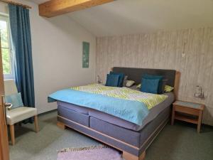 a bedroom with a large bed and a chair at Comfortabel vakantieappartement in Hofen