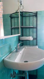 a white sink in a blue bathroom with a mirror at New Royal in Agerola