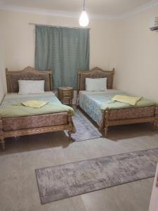 two beds sitting next to each other in a room at luxury 3BD villa in Stella Heights - North Coast فيلا فاخره ستيلا هايتس الساحل الشمالي in El Alamein