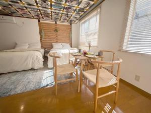 a bedroom with a bed and a table and chairs at 渋谷5分のダブルベット2台の40平米東京大学徒歩5分のアパート in Tokyo