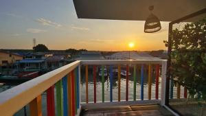 een balkon met een regenboog en een zonsondergang bij Pulau Ketam D'island beds&cafe in Bagan Pulau Ketam