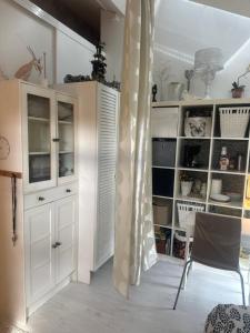 cocina con armarios blancos, mesa y silla en Small guest room en Turku