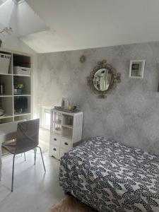 um quarto com uma cama, uma mesa e um espelho em Small guest room em Turku