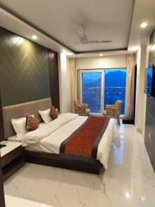 a bedroom with a large bed and a large window at Hotel Aaria in Mussoorie