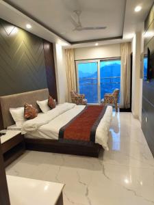 - une chambre avec un grand lit et une grande fenêtre dans l'établissement Hotel Aaria, à Mussoorie