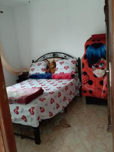 a small bed with a doll sitting on top of it at Charmante maison de campagne in Temara