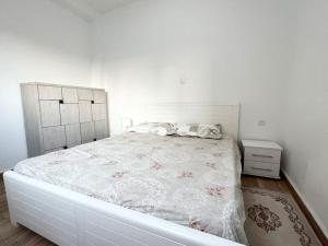 a white bedroom with a large bed with a white bedspread at Superbe appartement au cœur de Jijel in Jijel