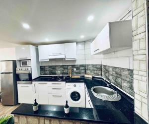 a kitchen with a sink and a washing machine at Superbe appartement au cœur de Jijel in Jijel