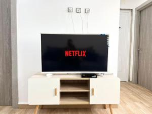 a television on a white entertainment center in a living room at Superbe appartement au cœur de Jijel in Jijel