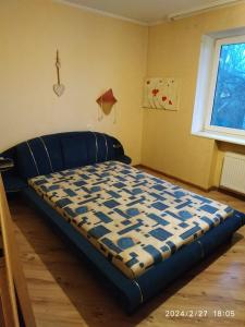 Cama azul en habitación con ventana en Family Villa Sarapin en Kretinga