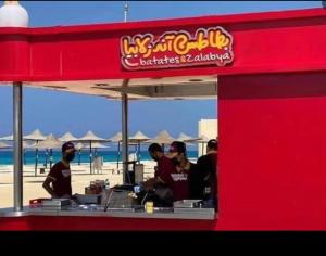 a group of people sitting at a counter at the beach at luxury 3BD villa in Stella Heights - North Coast فيلا فاخره ستيلا هايتس الساحل الشمالي in El Alamein