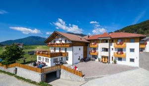 un grand bâtiment blanc avec un toit rouge dans l'établissement Der Brunnerhof, à Rio di Pusteria