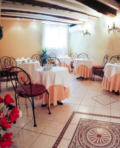 una habitación con mesas y sillas con mantel blanco en Antica Residenza Cicogna, en Siena