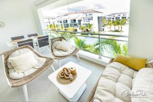 Las LagunasにあるSyrma 302 Estrella Dominicus Apartmentのソファと椅子、バルコニーのあるリビングルーム