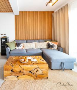 Las LagunasにあるSyrma 302 Estrella Dominicus Apartmentのリビングルーム(青いソファ、木製テーブル付)