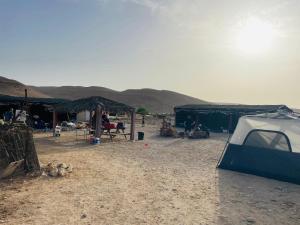 ein Zelt in der Wüste mit Bergen im Hintergrund in der Unterkunft חאן נחל חווה Han Nahal Hava in Mitzpe Ramon