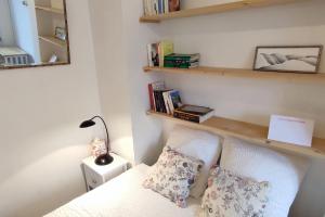 a bedroom with a bed and a shelf with books at Studio-Heart of town-Bd des Pyrenées-Quiet in Pau