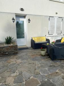 d'une terrasse avec deux canapés et une porte. dans l'établissement ila’s tiny house, à Limoges