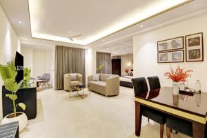 a living room with a couch and a dining room at Saltstayz Amara - Near MG Road and Sector 29 in Gurgaon