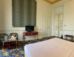 1 dormitorio con 1 cama y escritorio con TV en Windsor Palace Luxury Heritage Hotel Since 1906 by Paradise Inn Group, en Alejandría