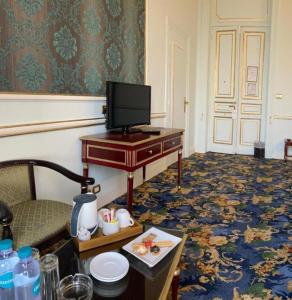 Habitación con escritorio y TV. en Windsor Palace Luxury Heritage Hotel Since 1906 by Paradise Inn Group, en Alejandría