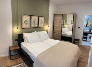 a bedroom with a large white bed and a mirror at Apartments INCIS next to the Pula Amphitheather in Pula